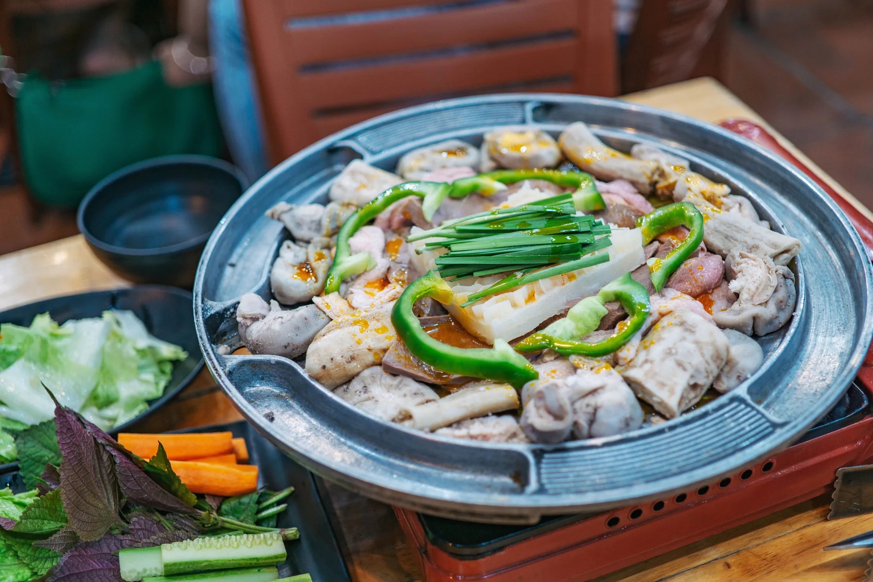 Korean barbecue with meat, vegetables and side dishes on a tabletop grill
