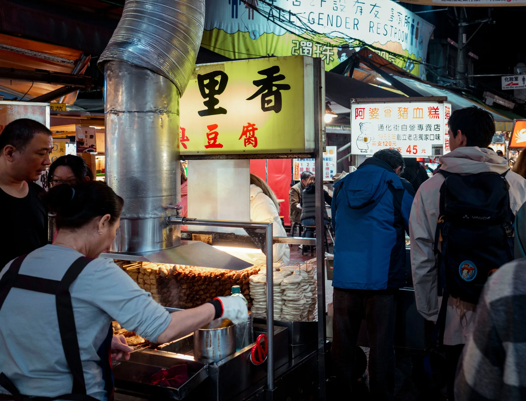 Visitors at a busy Taiwanese night market with open food stalls