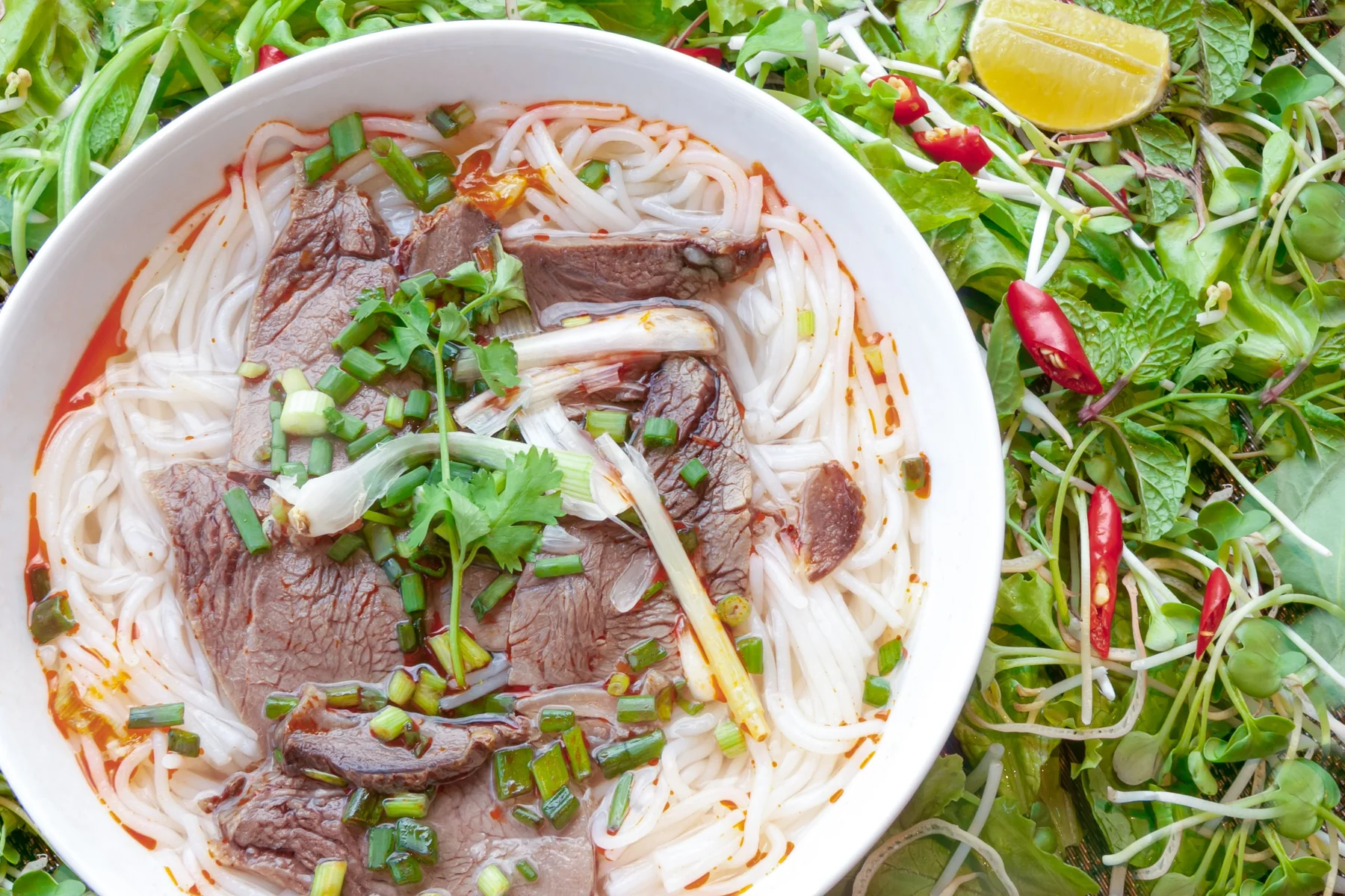 Vietnamese beef noodle soup with herbs and lime