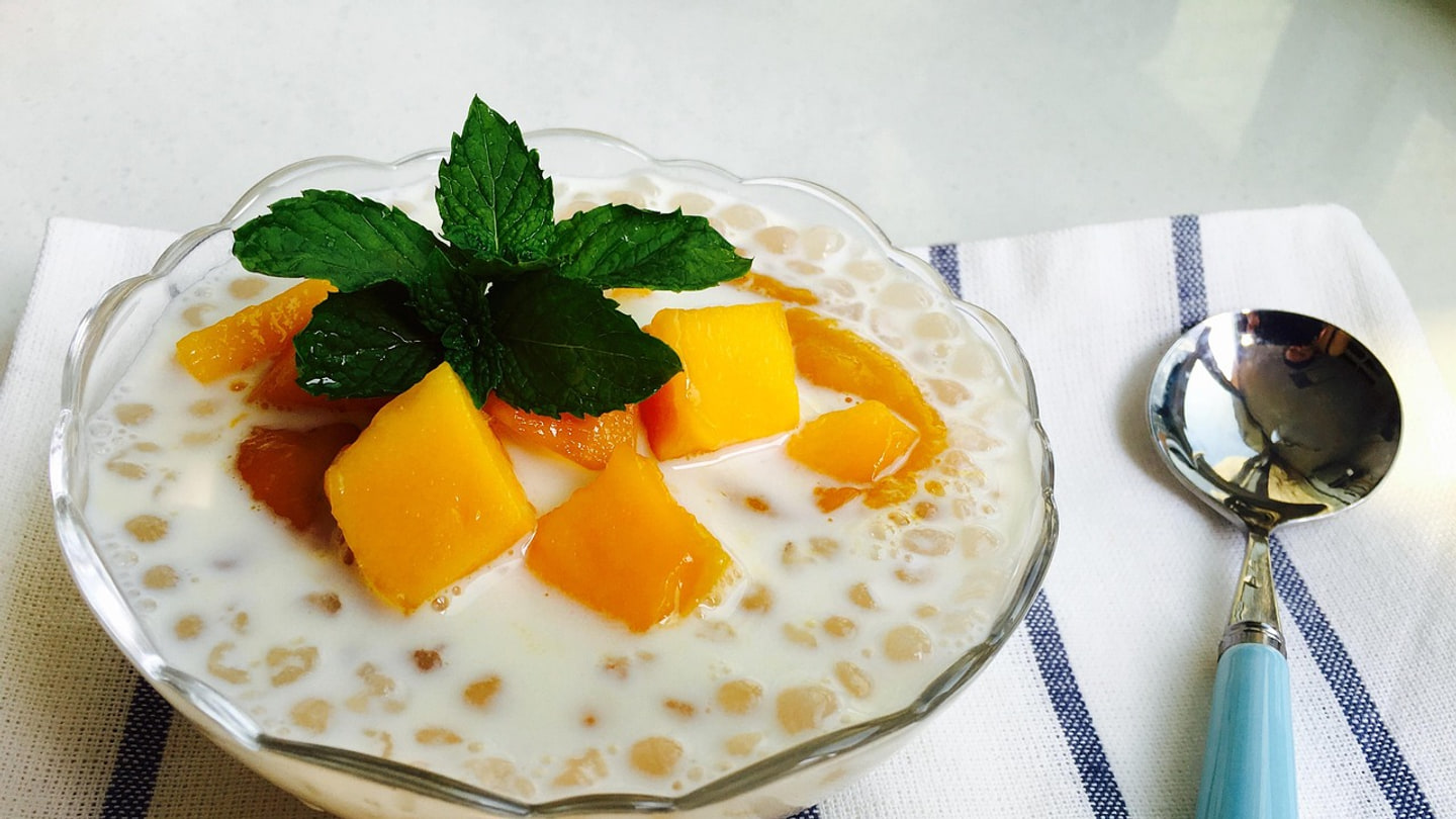 Mango sago với nước cốt dừa, hạt tapioca nhỏ, xoài cắt miếng và bạc hà