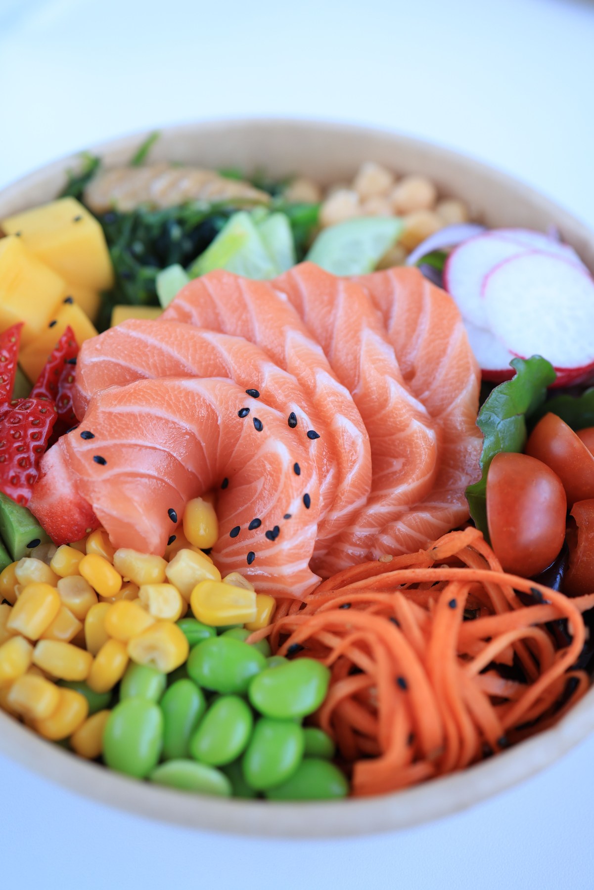 Salmon poke bowl with rice, avocado, edamame and vegetables