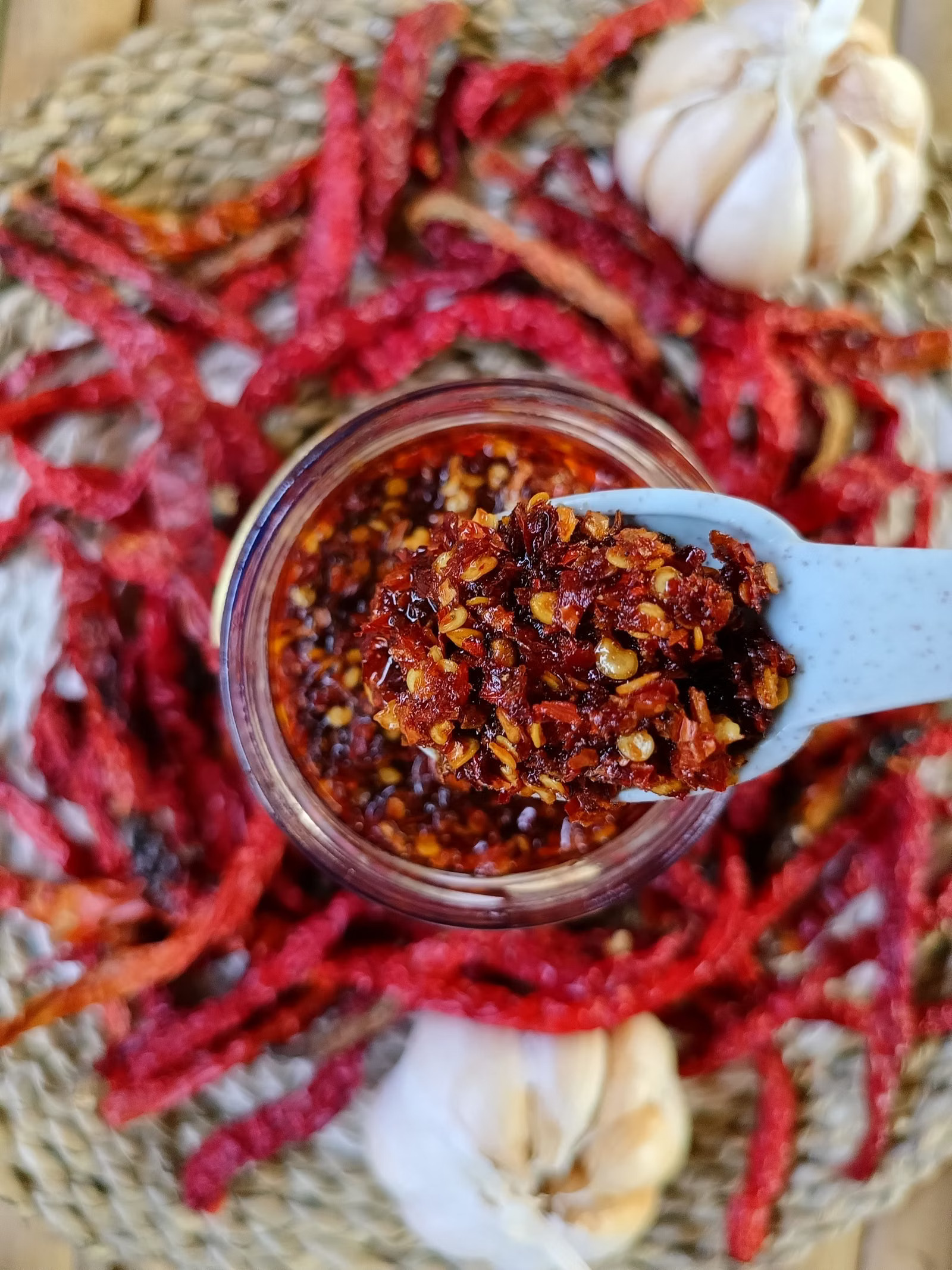 Glas mit Chiliöl, Knoblauch und getrockneten Chilis