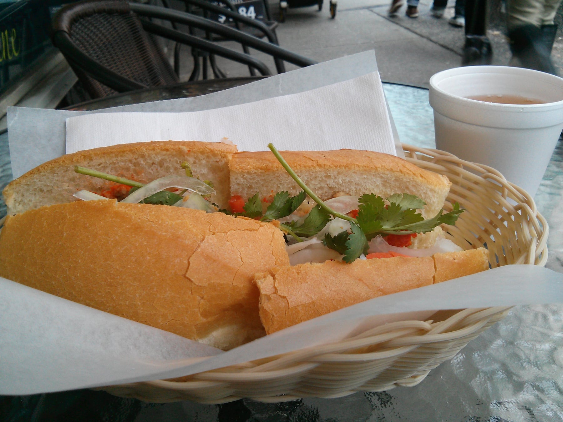 Ổ bánh mì Việt Nam kẹp thịt, đồ chua và rau thơm tươi.