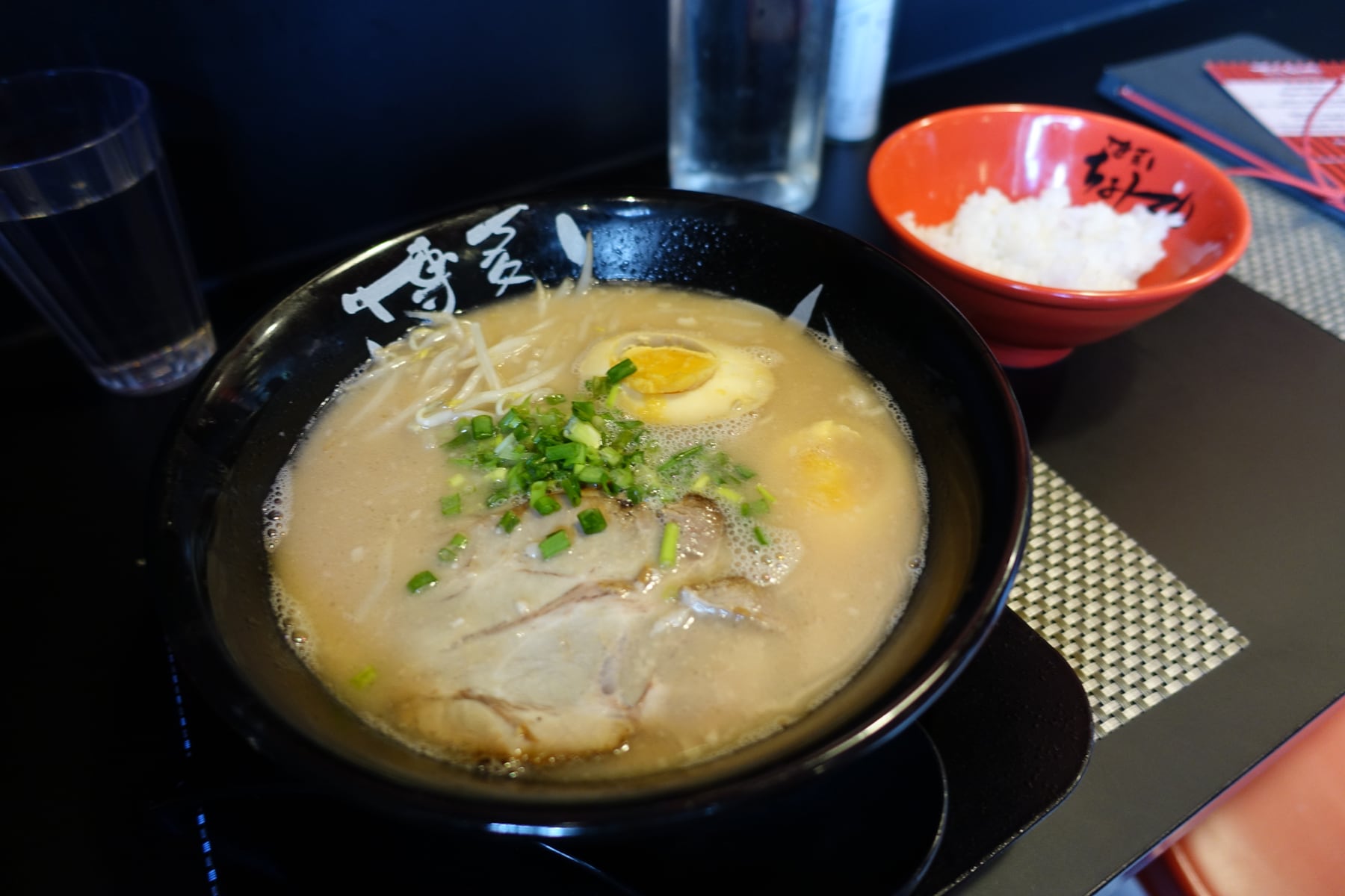 A bowl of miso ramen with noodles, vegetables, egg and nori.