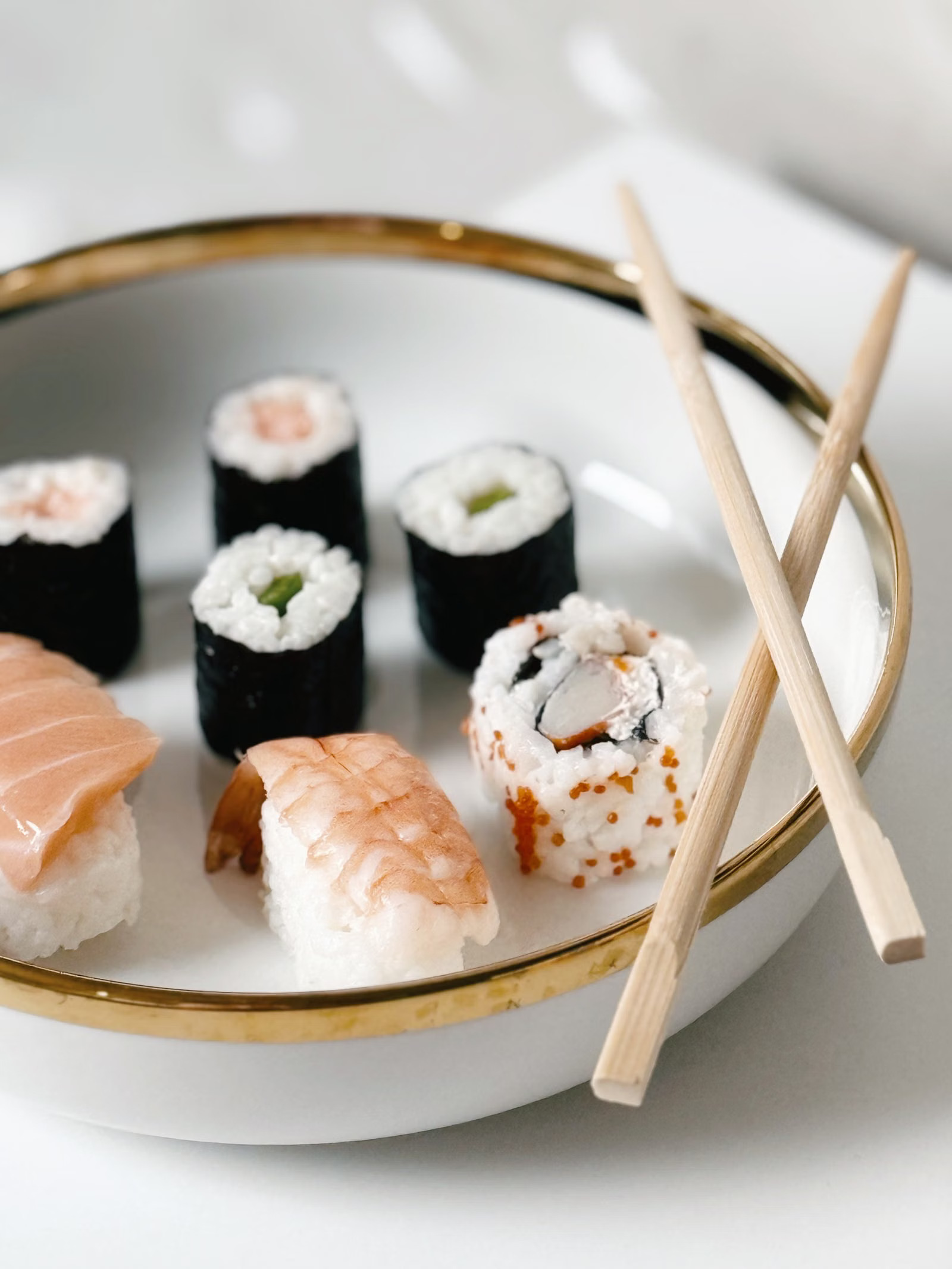 Sushi-Platte mit verschiedenen Rollen und Stäbchen